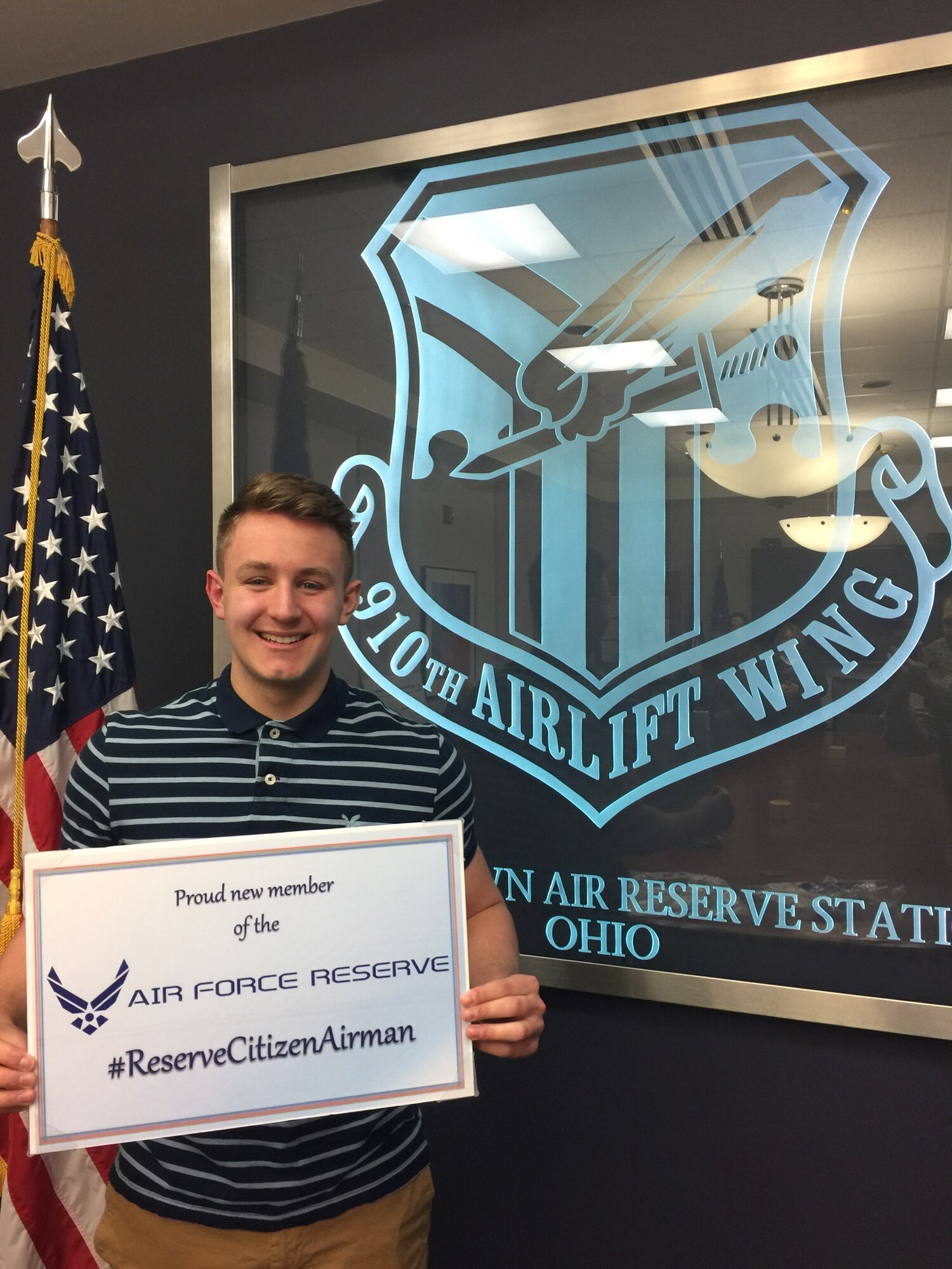 Robert Adler, a new recruit to the 910th Security Forces Squadron, holds an Air Force Reserve sign after taking the oath of enlistment to become a Reserve Citizen Airmen here, Jan. 29, 2018.