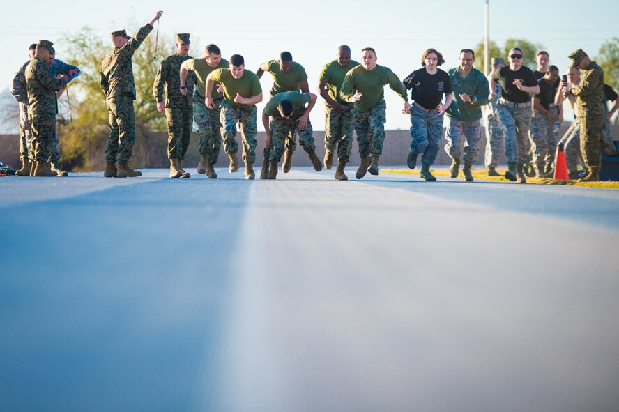 Airmen and Marines run during a combat fitness test challenge at Luke Air Force Base, Ariz., Jan. 26, 2018. The CFT, a Marine Corps physical fitness requirement, started with an 880 yard sprint before moving on to several other combat-related tasks. The challenge between Airmen and Marines was held to build esprit de corps between the two services. (U.S. Air Force photo/Staff Sgt. Jensen Stidham)