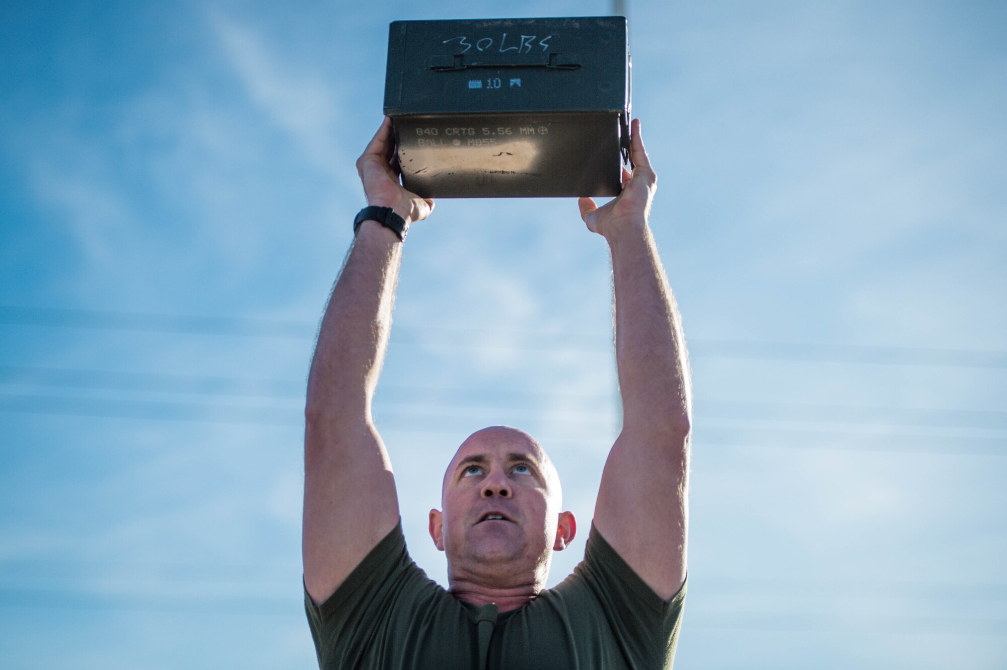 A Marine performs an ammo can lift during a combat fitness test challenge at Luke Air Force Base, Ariz., Jan. 26, 2018. During the CFT, a 30 pound ammo can was lifted above the head as many times as possible in two minutes. The challenge between Marines and Airmen was held to build esprit de corps among the two services. (U.S. Air Force photo/Staff Sgt. Jensen Stidham)