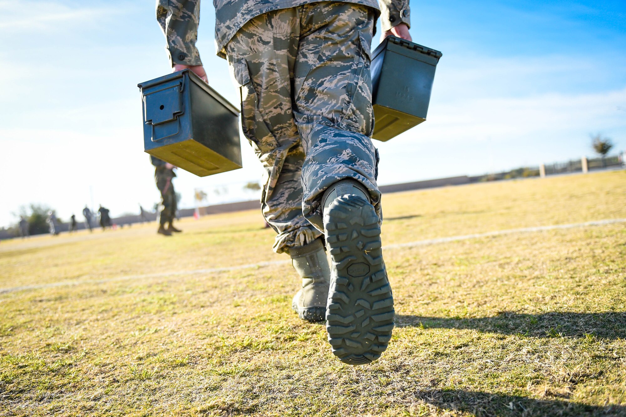 An Airman assigned to the 56th Fighter Wing carries two ammo cans during a combat fitness test challenge at Luke Air Force Base, Ariz., Jan. 26, 2018. During portions of the CFT, a Marine Corps physical fitness requirement, Airmen and Marines carried two 30 pound ammo cans. The competition was held to build esprit de corps between the two services. (U.S. Air Force photo/Staff Sgt. Jensen Stidham)