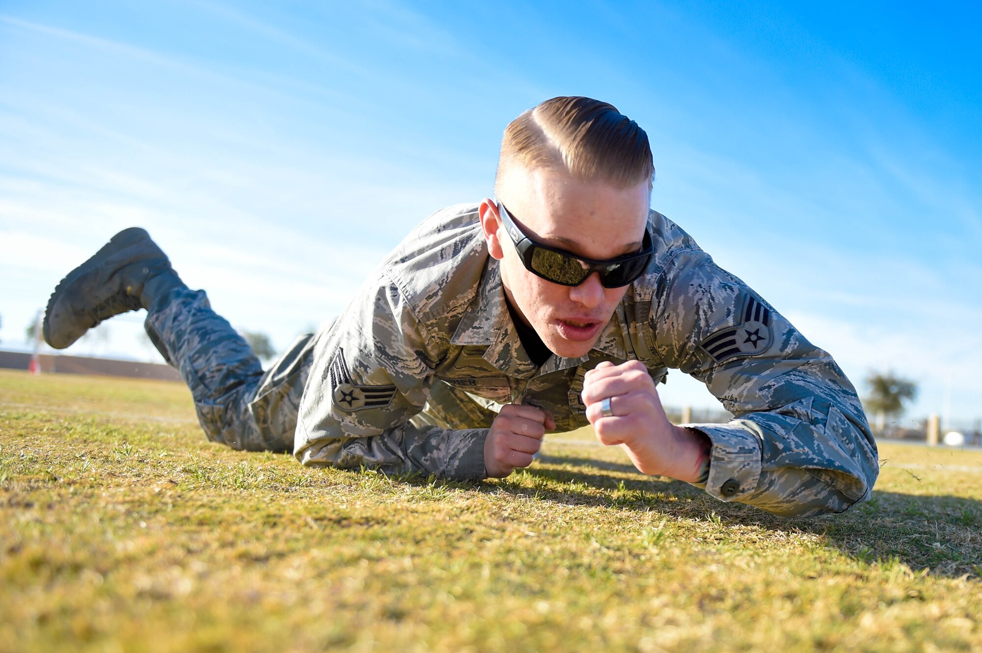 Senior Airman Devon Tanner, 56th Communications Squadron network infrastructure technician, performs a low-crawl during a combat fitness test challenge at Luke Air Force Base, Ariz., Jan. 26, 2018. Airmen and Marines completed the CFT together to build esprit de corps among the two services. (U.S. Air Force photo/Staff Sgt. Jensen Stidham)