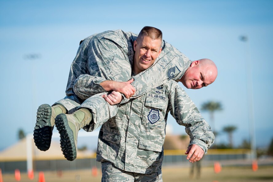 Brig. Gen. Brook Leonard, 56th Fighter Wing commander carries Master Sgt. Herbert Williams, 56th Communications Squadron infrastructure transport systems noncommissioned officer in charge, during a combat fitness test challenge at Luke Air Force Base, Ariz., Jan. 26, 2018. The challenge was held between Marines and Airmen to build esprit de corps among the two services while providing intense physical fitness. (U.S. Air Force photo/Staff Sgt. Jensen Stidham)