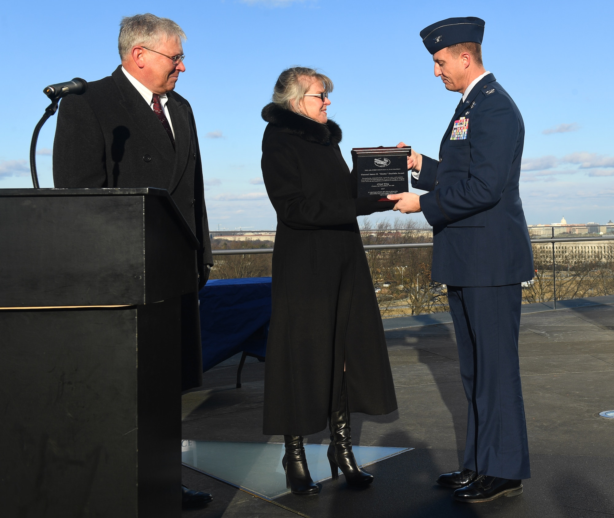 Ms. Jonna Doolittle Hoppes, executive director of the Doolittle Foundation and granddaughter of Gen. James “Jimmy” Doolittle, and retired Lt. Gen. Christopher Miller, president of the Air Force Historical Foundation, present the General James H. “Jimmy” Doolittle award to Col. Julian Cheater on behalf of the 432nd Wing/432nd Air Expeditionary Wing Jan. 18, 2018, at Creech Air Force Base, Nev. The General James H. “Jimmy” Doolittle award is presented to units who display gallantry, determination, espirit de corps and superior management of joint operations in accomplishing its mission under difficult and hazardous conditions in multiple conflicts. (U.S. Air Force photo/Senior Airman James Thompson)