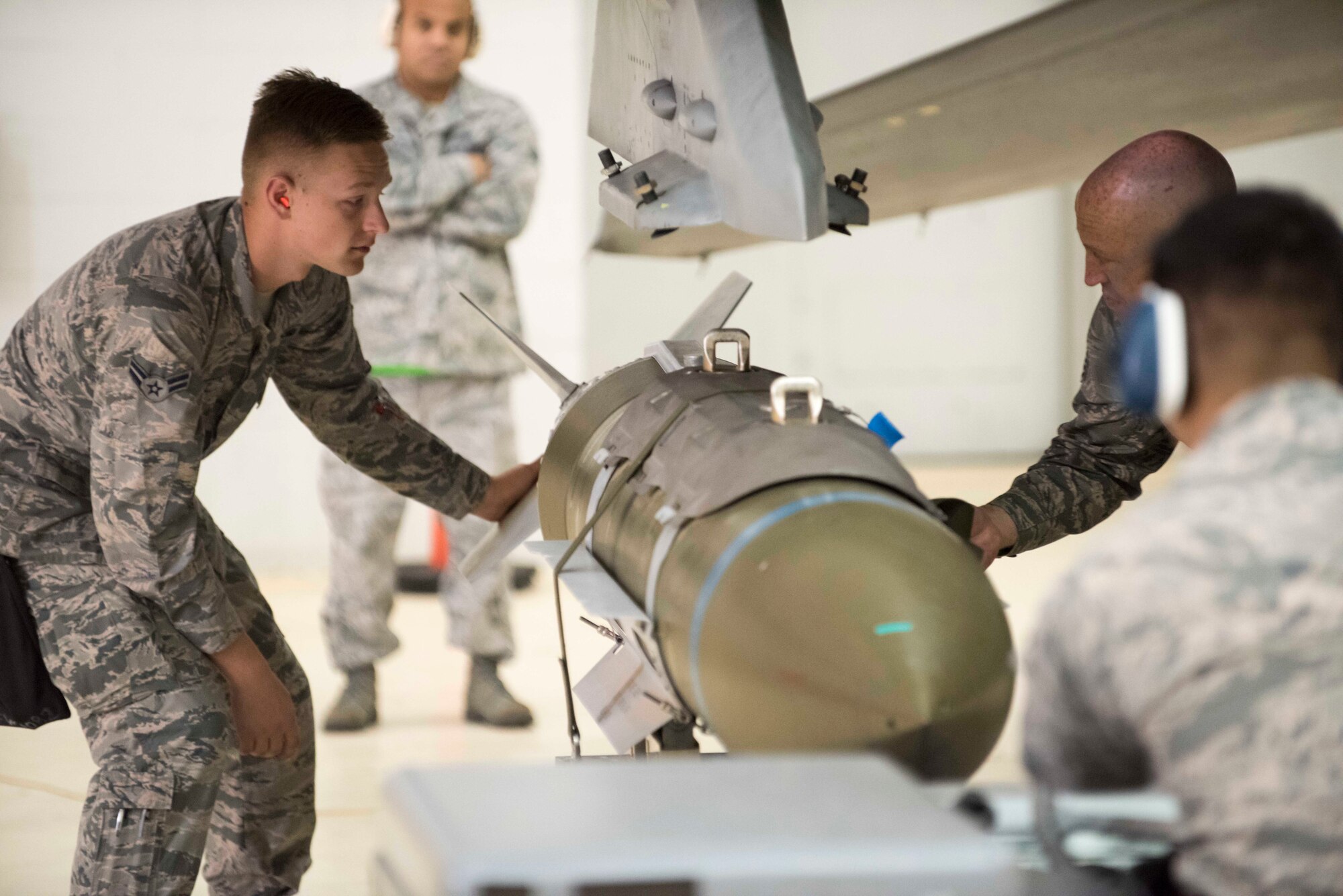 Weapons loaders prepare to load a GBU-31 Joint Direct Attack Munition onto an Edwards jet in the Fourth Quarter Weapons Load Competition held Jan. 8, 2018. The 412th Maintenance Group’s Load Crew of the Year Competition is slated for Feb. 5. (U.S. Air Force photo by Kyle Larson)