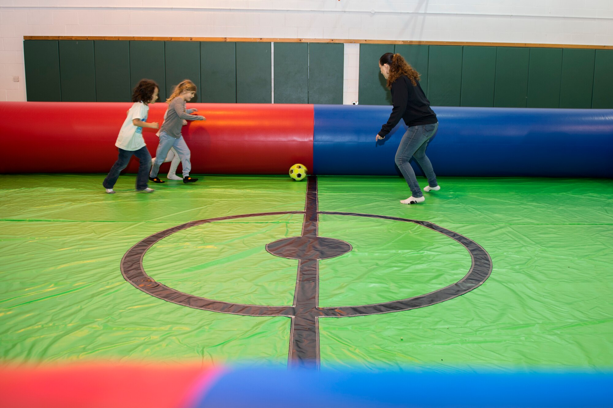 Children and Youth Center staff play a game of indoor soccer at RAF Alconbury, United Kingdom, Jan. 26, 2018. The sport game is part of a Get Fit Challenge where children and adults exercise while also maintaining a fun and engaging experience. (U.S. Air Force photo by Senior Airman Chase Sousa)