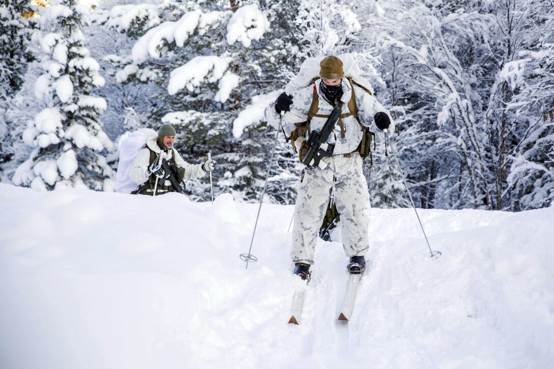 A Marine skiing down a small hill.