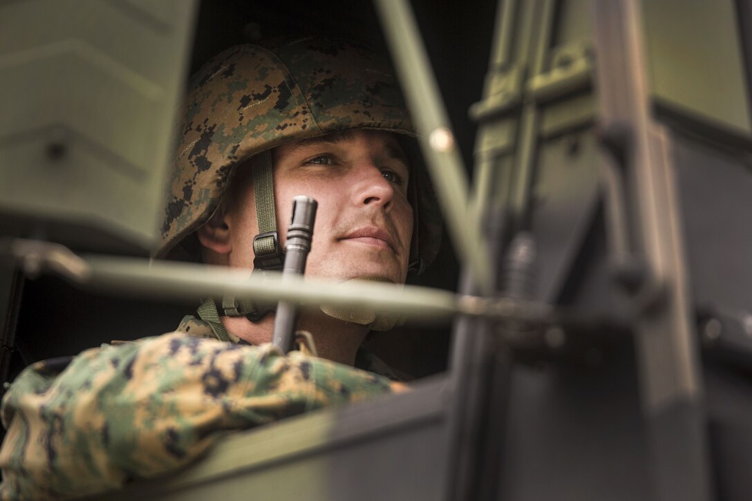 Marine Corps Master Sgt. John W. Miles leads a convoy operation riding in a tactical vehicle.