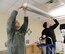 Staff Sgt. Lt Money and Amn. Steven Geiger, both with the 552nd Maintenance Squadron, change lightbulbs in an infant room at the Child Development Center East during a squadron volunteer project Jan. 16.