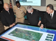 IMAGE: DAHLGREN, Va. (Jan. 16, 2018) – Naval Surface Warfare Center Dahlgren Division (NSWCDD) Innovation Lab (iLab) Director of Innovation Nelson Mills briefs the Commander of Naval Sea Systems Command (NAVSEA) Vice Adm. Thomas Moore, NAVSEA Command Master Chief Robert Crossno, and NSWCDD Commanding Officer Capt. Gus Weekes, on the use of digital collaboration tables as visual aids for surface ships. The collaboration table could provide capabilities to view ship doctrine, navigation tracks, radar information, and Automatic Identification System information for situational awareness. The iLab – equipped with state-of-the-art equipment, services, and trained personnel – opened for business last summer as an intensive collaborative environment where the command's experts work to speed up and maximize corporate innovative solutions across the laboratory. 

The iLab was one stop in the admiral's tour of Dahlgren, which gave him an opportunity to meet with the command's leaders, scientists, and engineers. It was the first in a series of scheduled visits to the NAVSEA Warfare Center divisions under the theme of “Warfare Centers – The Campaign Plan in Action.” While at the iLab, Weekes briefed the NAVSEA commander on Dahlgren technical programs, including directed energy, electromagnetic railgun, chemical, biological, and radiological defense, as well as leadership development. Moore's Campaign Plan is focused on three mission priorities: on-time delivery of ships and submarines, culture of affordability, and cybersecurity. These priorities address today's challenges and provide the focus to achieve NAVSEA's mission and support the Fleet.