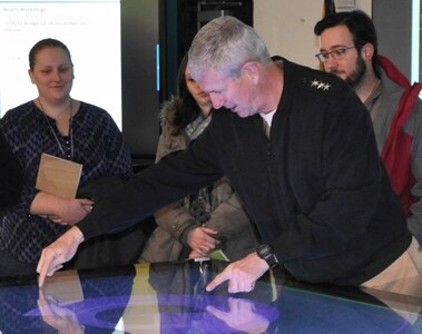 IMAGE: DAHLGREN, Va. (Jan. 16, 2018) – Vice Adm. Thomas Moore, commander of Naval Sea Systems Command (NAVSEA), interacts with the digital collaboration table at the Naval Surface Warfare Center Dahlgren Division (NSWCDD) Innovation Lab (iLab). NSWCDD scientists and engineers use the collaboration table as a visual aid for surface ships at the iLab. It could provide capabilities to view ship doctrine, navigation tracks, radar information, and Automatic Identification System information for situational awareness. The iLab – equipped with state-of-the-art equipment, services, and trained personnel – opened for business last summer as an intensive collaborative environment where the command's experts work to speed up and maximize corporate innovative solutions across the laboratory.