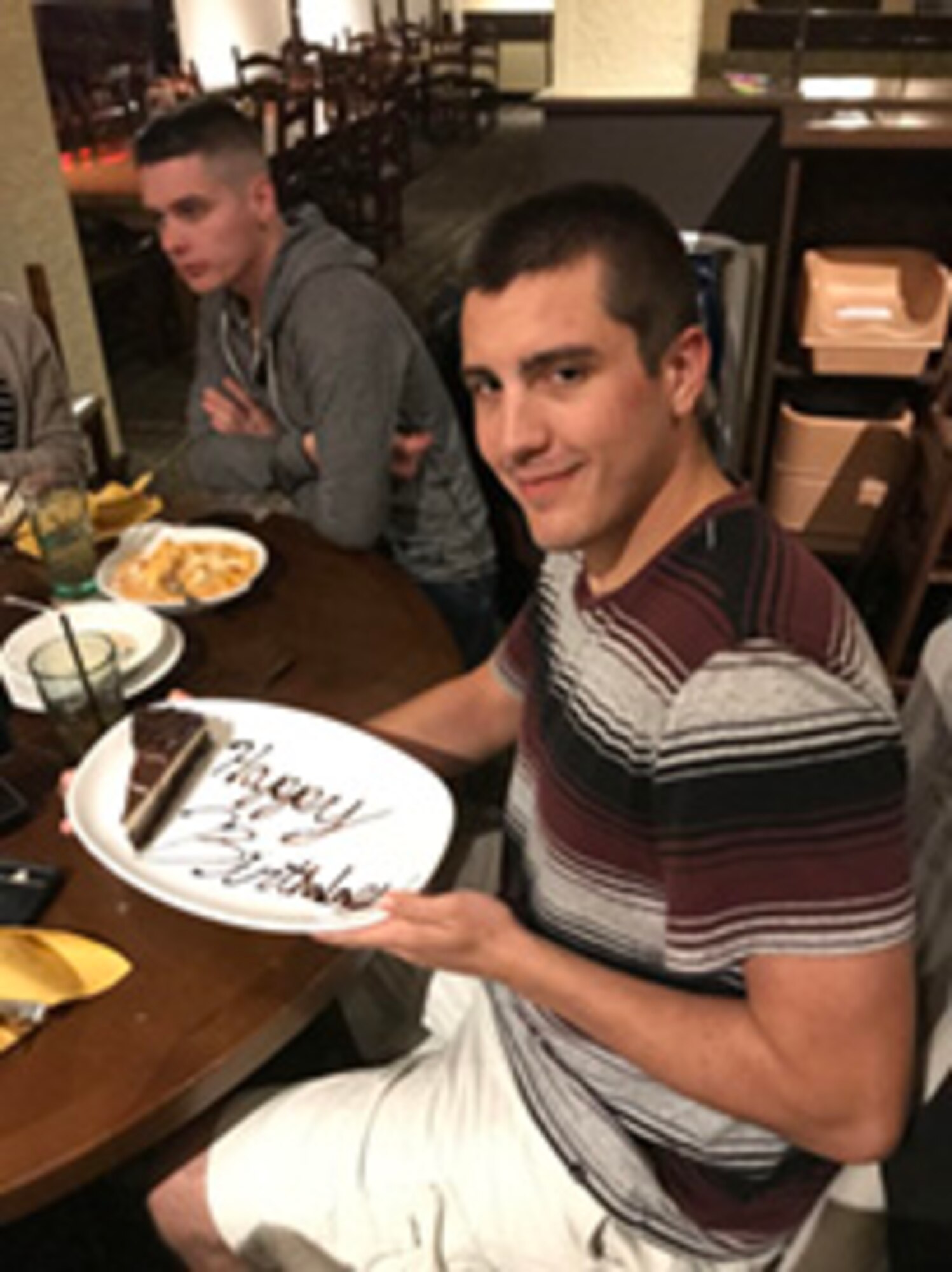 From left, Team Tinker Home Away from Home participants and cousins, Staff Sgt. Andrew “Andy” Roach and Senior Airman Jacob Roach celebrate Jacob’s birthday with their host family.