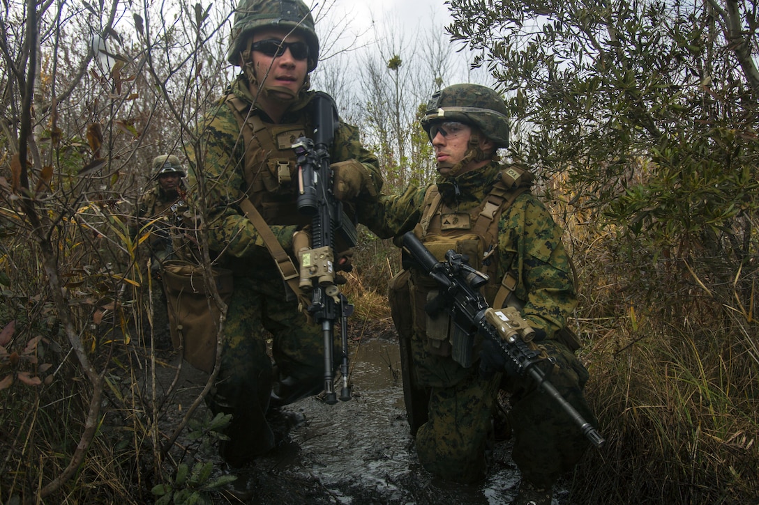 Two Marines talk during a live-fire training exercise.