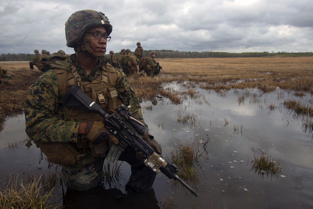Marine posts security in field during an exercise.