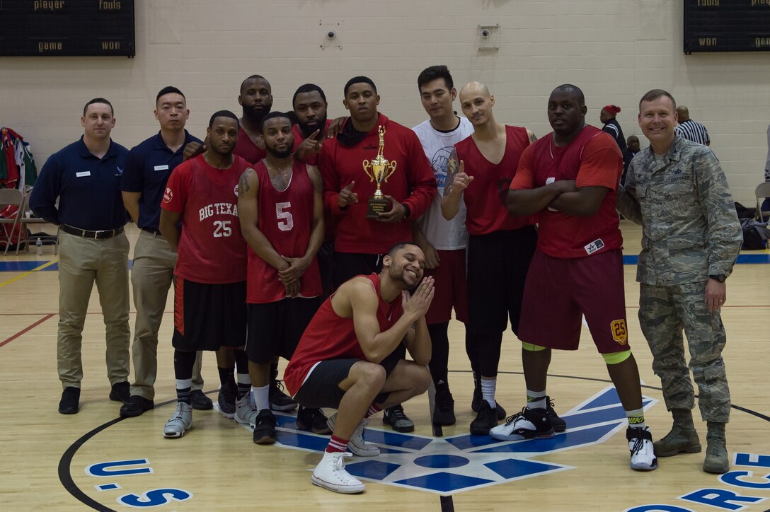 The 633 Force Support Squadron intermural basketball team pose for a with the championship trophy alongside U.S. Air Force Col. David Stanfield 633 Mission Support Group commander after the intermural basketball championship game at the Shellbank Fitness Center, Joint Base Langley-Eustis, Va., Jan. 25, 2018.