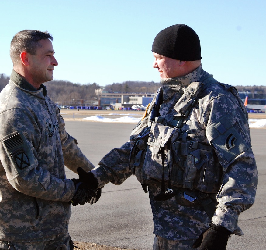 New York Army National Guard Lt. Col. Kevin Ferreira, left, shakes hands and congratulates Chief Warrant Officer 5 Michael Johnson.