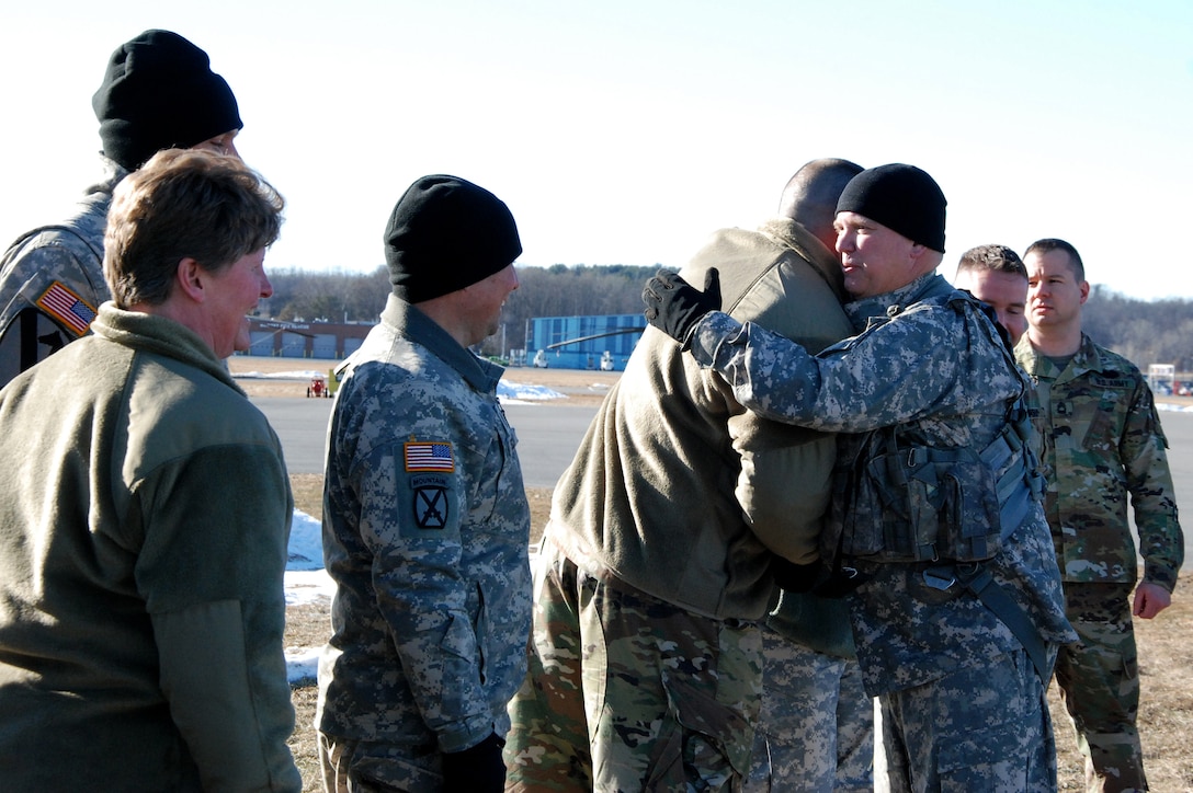 Guardsmen greet and congratulate an Army pilot after his final flight.