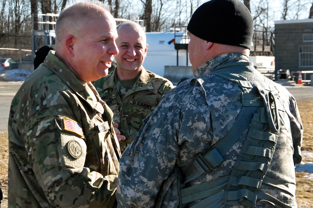 An Army commander congratulates an Army pilot after his final flight.