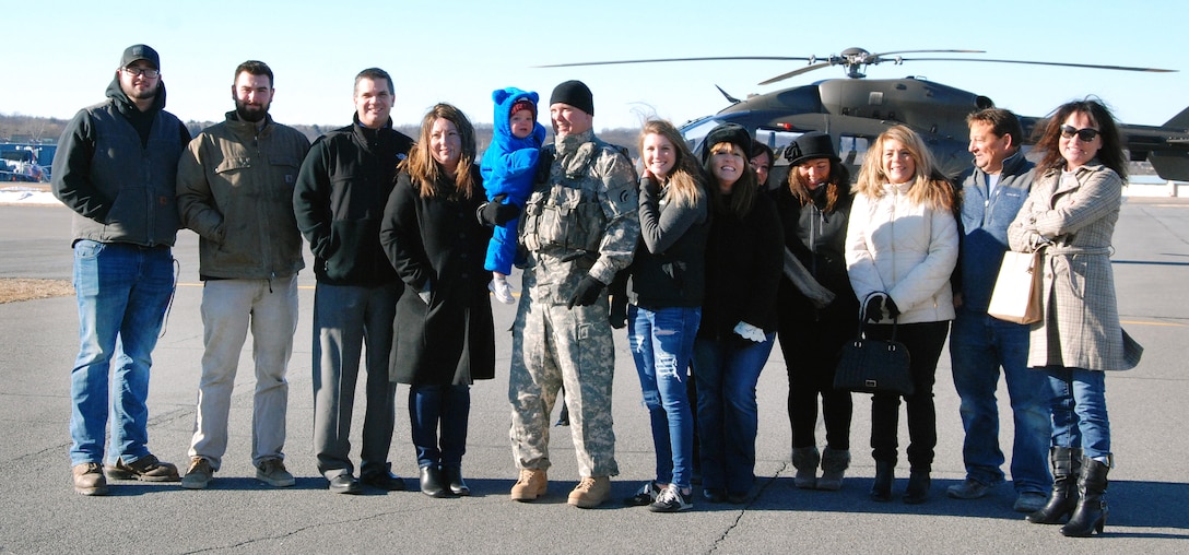An Army pilot, center, poses for a photograph with his family.