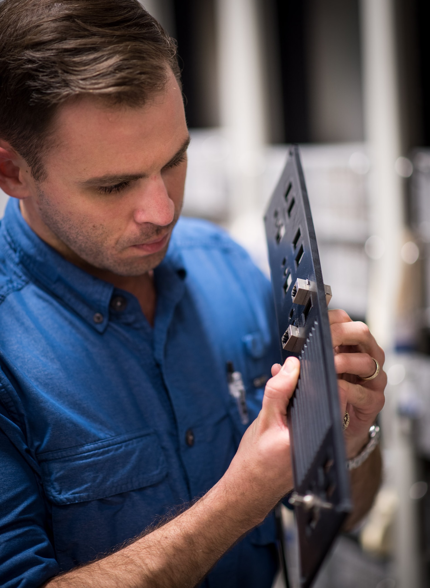 SPAWAR Systems Center (SSC) Atlantic employee Paul Lataille fit tests network cable adapters in a 3D printed rack-mount patch panel. By using Additive Manufacturing technology (aka 3D printing), SSC Atlantic engineers and scientists can design and create prototypes for new components and replacement parts, and enhance and modify existing products. SSC Atlantic develops, acquires and provides life cycle support for command, control, communications, computer, intelligence, surveillance and reconnaissance (C4ISR) systems, information technology and space capabilities. A leading-edge Navy engineering center, SSC Atlantic designs, builds, tests, fields and supports many of the finest frontline C4ISR systems in use today, and those being planned for the future.