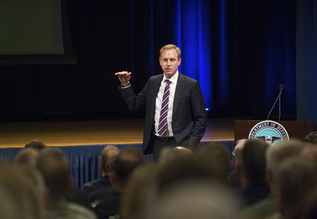 Deputy Defense Secretary Patrick M. Shanahan gestures while standing and speaking to an audience.
