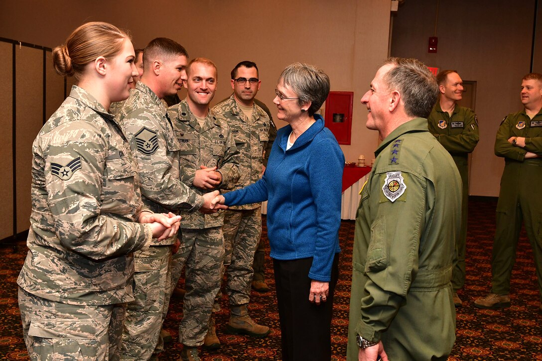 Secretary of the Air Force shakes hands with airmen next to the Air Force Chief of Staff.