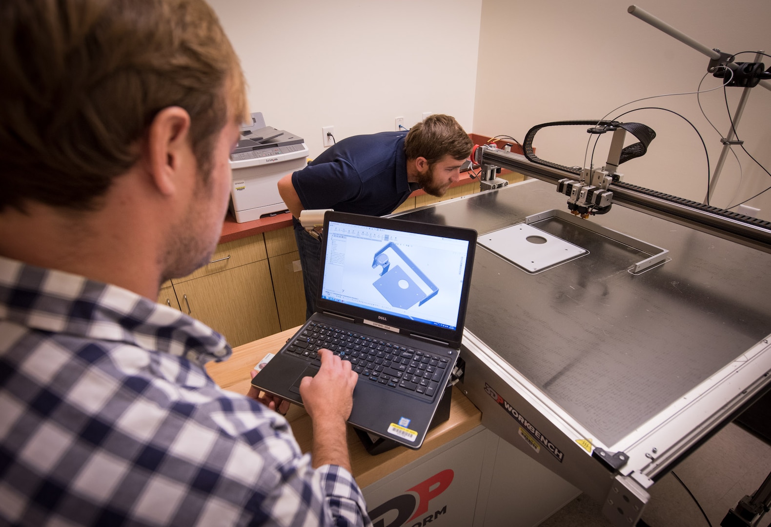 Space and Naval Warfare Systems Center Atlantic employees review CAD software designs for additive manufacturing and verify printer is properly calibrated, Charleston, South Carolina, October 24, 2017 (U.S. Navy/Joe Bullinger)