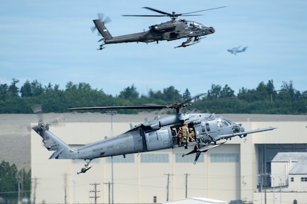 An Alaska Air National Guard HH-60 Pave Hawk, foreground, approaches the flight line as a U.S. Army AH-64 Apache and a U.S. Air Force C-17 Globemaster III fly in the background during the Arctic Thunder Open House at Joint Base Elmendorf-Richardson, Alaska, July 1, 2018. This biennial event hosted by JBER is one of the largest in the state and one of the premier aerial demonstrations in the world. The event features multiple performers and ground acts to include the JBER joint forces, U.S. Air Force F-22 and U.S. Air Force Thunderbirds demonstrations teams, June 30-July 1.