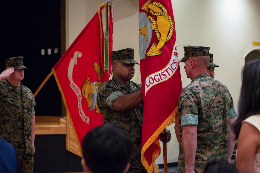 Lt. Col. Kenric D. Stevenson (center), outgoing commanding officer of Combat Logistics Regiment 35, 3rd Marine Logistics Group takes hold of the regimental colors to pass to the incoming commanding officer during a change of command ceremony July 2, 2018 on Camp Kinser, Okinawa, Japan. Stevenson relinquished command of CLR-35 to Col. Joon H. Um. Stevenson is a native of DeRidder, Louisiana. Um is a native of Tampa, Florida. (U.S. Marine Corps photo by Cpl. Joshua S. Pinkney)