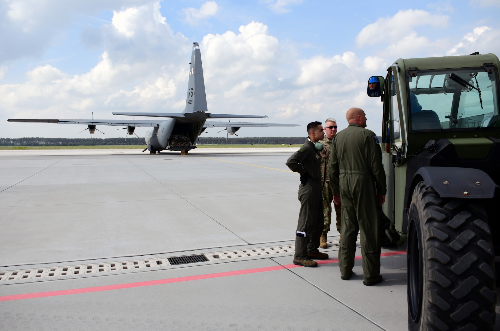 DDXX team members prepare to offload a pallet from an Air Force C-130 on the flight line in Powidz, Poland.