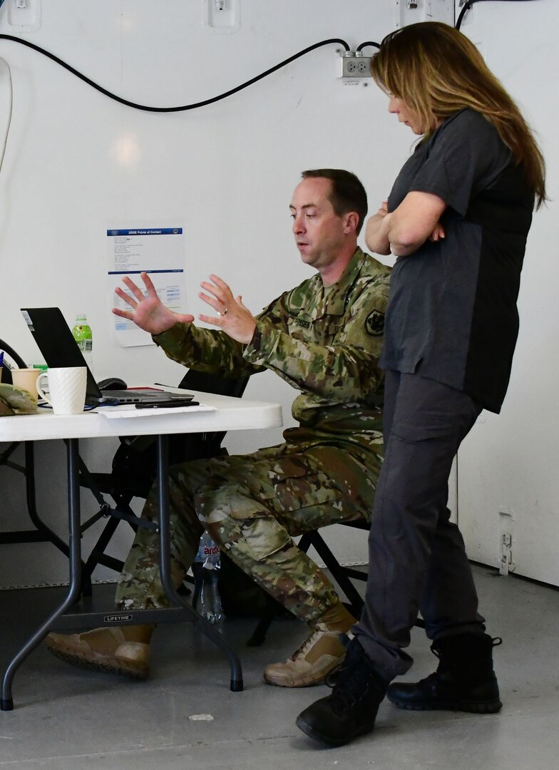 Maj. Grant Thimsen, Officer-In-Charge, Distribution Depot Powidz, Poland, and Mystra Tillotson, supply systems analyst, discuss standard procedures while deployed to support exercise Saber Strike 2018 and Operation Atlantic Resolve.