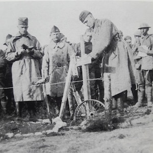 New York National Guard Chaplain (Cpt.) Father Francis P. Duffy, the chaplain of New York's famed "Fighting 69th," reads a service as a cross is placed on the grave of Lt. Quentin Roosevelt in August 1918. Duffy's commander, Col. Robert McCoy, had been an  aide to President Theodore Roosevelt and knew Quentin.