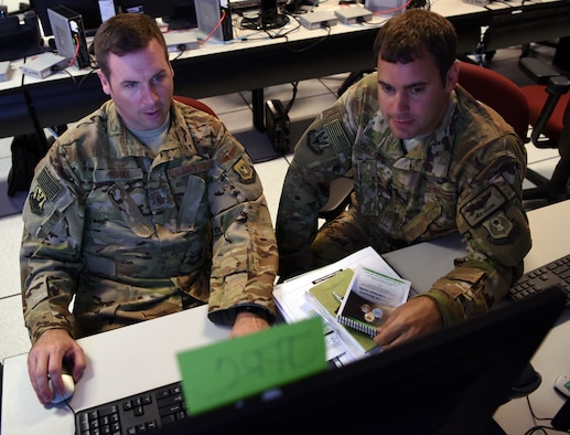 Master Sgt. Brian Yorke, left, Staff Exercise 18-4 Joint Personnel Recovery Center planner, and Maj. Rob Arduini, STAFFEX 18-4 planner, both from Ninth Air Force, discuss JPRC options available for the exercise scenario, June 20, 2018, at Shaw Air Force Base, S.C. The STAFFEX scenario featured a humanitarian assistance effort in the U.S. Africa Command area of responsibility. This is the fourth STAFFEX Ninth Air Force has held since November 2017 as it works toward certification as a Joint Task Force-capable headquarters in the Air Force. (U.S. Air Force photo by Tech. Sgt. Amanda Dick)