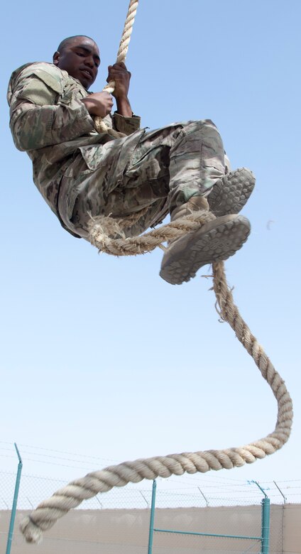 U.S. Army Sgt. Nigel Charles, a military policeman attached to the Combined Joint Task Force — Operation Inherent Resolve, climbs a rope on the obstacle course during U.S. Army Central's 2018 Best Warrior Competition at Camp Buehring, Kuwait, June 29, 2018. Challenges that are physically difficult create valuable training opportunities to promote readiness in a deployed environment.