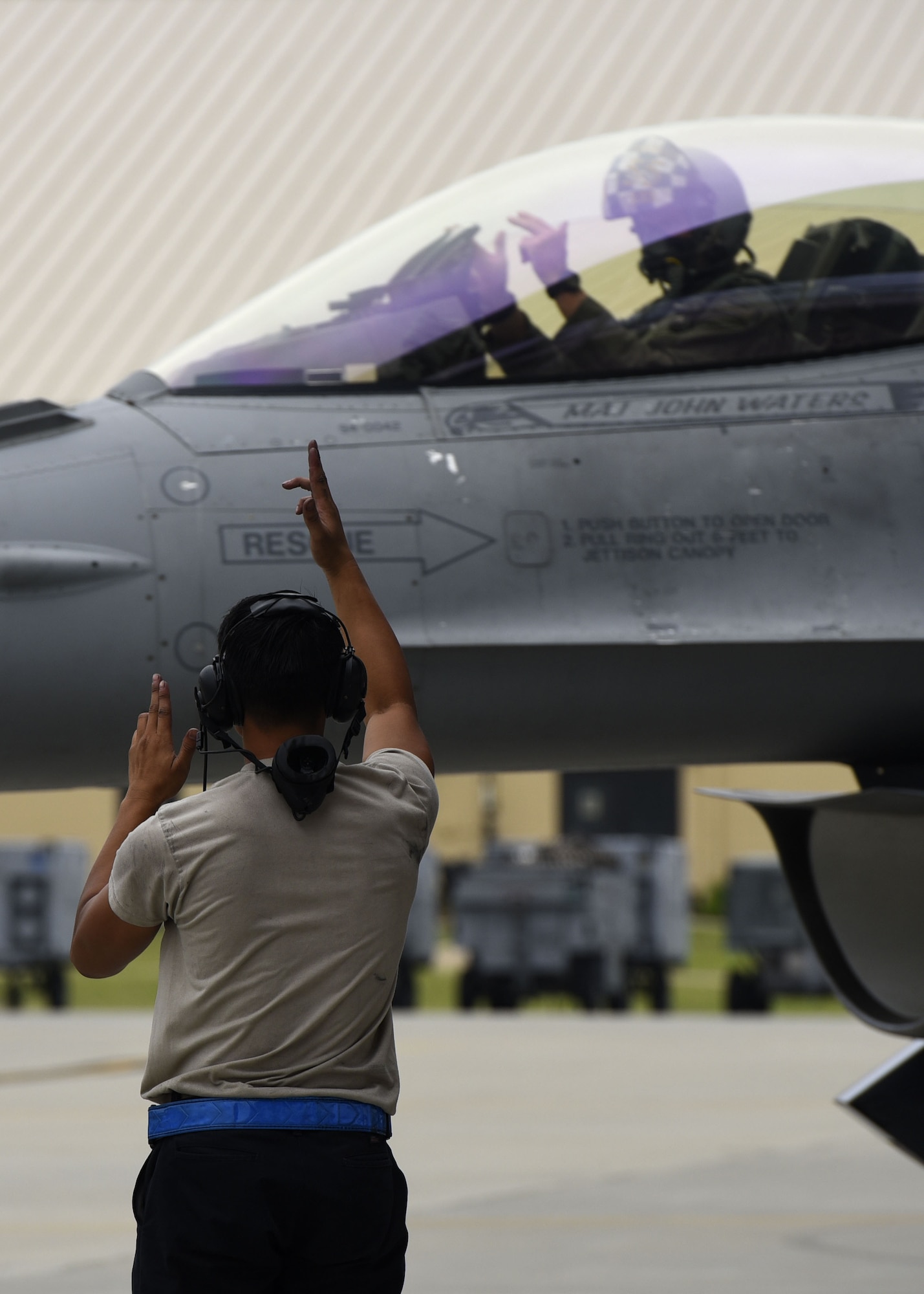 A U.S. Air Force maintainer assigned to the 20th Maintenance Group, left, signals “Roll’em,” a 55th Fighter Squadron (FS) saying, to an F-16CM Fighting Falcon pilot assigned to the 55th FS at Shaw Air Force Base, S.C., June 27, 2018.