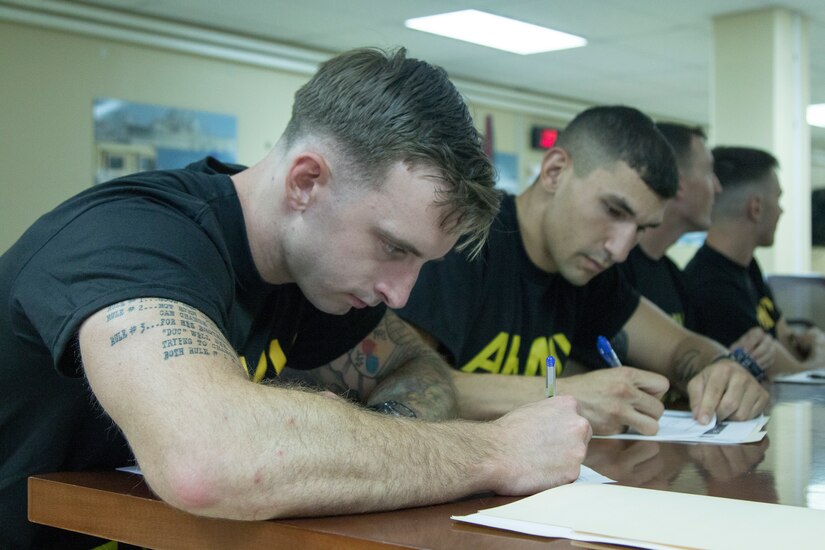 U.S. Army Spc. Cameron Gaylor left, a healthcare specialist assigned to Army Support Group - Kuwait, and Spc. Alexander Dillon right, a military policeman assigned to the ARCENT Personal Security Detachment, fill out paperwork during registration for the 2018 U.S. Army Central Best Warrior Competition at Camp Arifjan, Kuwait, June 27, 2018. The best warrior competition is held to promote morale and cohesion, and to reinforce the importance of individual excellence within the profession.