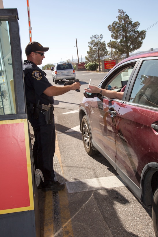 Officer Timothy Kenworthy, Marine Corps Police Department, checks a Common Access Card with a handheld RapidGate scanner so the driver can enter Marine Corps Logistics Base Barstow, Calif. The commercially available RapidGate ID security system is slated to be replaced by the Defense Biometric Identification System, DBIDS, beginning in August.
