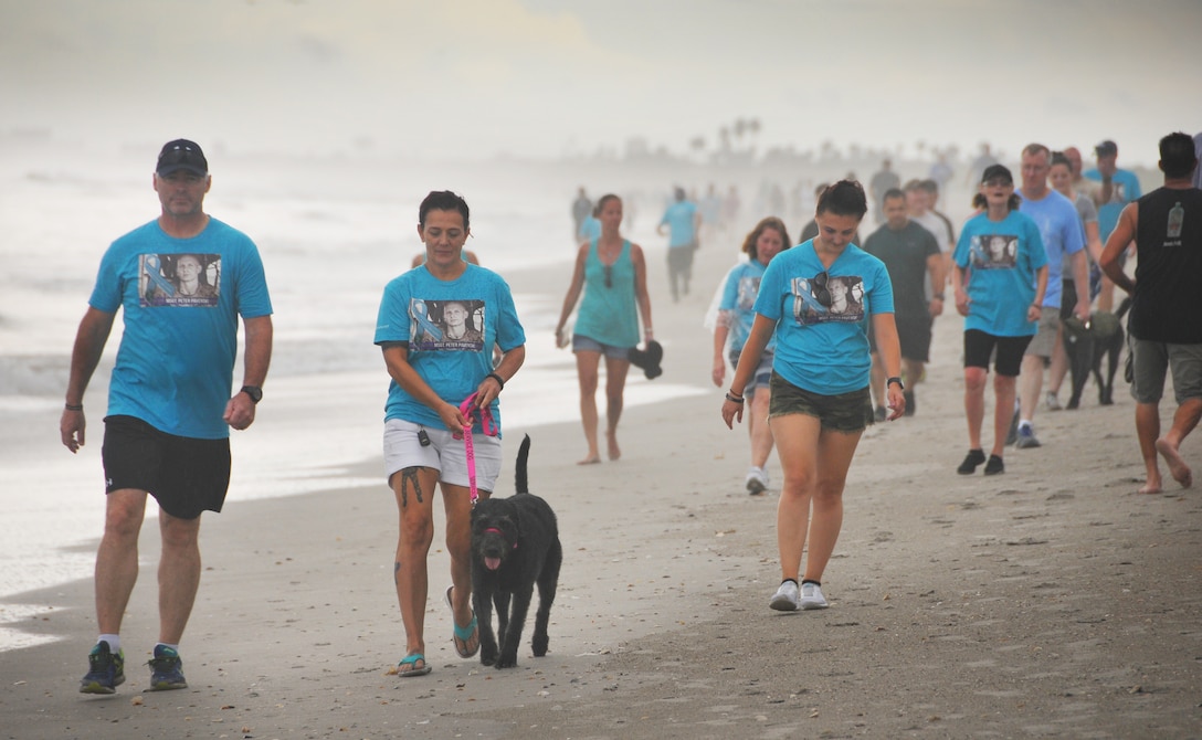 Air Force veteran Stacey Pavenski, center, 46, of Palm Bay, Florida, walks on the beach with her therapy dog, Memphis Belle. Pavenski is on a journey to bring awareness to PTSD and traumatic brain injury disorders that lead 22 veterans a day to take their own lives. Her husband Air Force Master Sgt. Pete Pavenski took his own life Sept. 18, 2018. To help with the healing process, Pavenski joined forces with Mission 22, a non-profit organization, to put together a PTSD 3K walk-run on Florida’s Space Coast during PTSD Awareness Month June 30. Approximately 300 people registered for the walk. (Courtesy Malcolm Denmark)