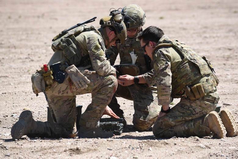 Three Airmen from 90th Civil Engineer Squadron Explosive Ordnance Disposal flight prepare explosives for detonation during a three-day field training exercise June 27, 2018, at the EOD range, F.E. Warren Air Force Base, Wyo. The training allowed the EOD Airmen the opportunity to practice real-world scenarios which will allow them to conduct the mission in a safe and effective manner. (U.S. Air Force photo by Airman 1st Class Abbigayle Wagner)