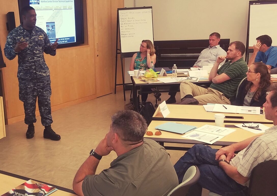 IMAGE: NSWC Dahlgren Division Commanding Officer Capt. Godfrey 'Gus' Weekes briefs new first-line supervisors from divisions across the Naval Warfare Centers on the first day of their five-day Propel training course. "I applaud the fact that you applied (for the supervisory position) and are showing others that it is important to be outside of your comfort zone and to contribute as leaders," said Weekes, who recommended a book he just finished reading called 'Neptune's Inferno' about the World War II naval battle for Guadalcanal. "If you need anything to get your mind sharper on why we do what we do, and the need to ensure that the Fleet understands the way the combat system actually works - the capability it actually provides - read or listen to that book."

Propel provides an introductory level awareness of the Warfare Center expectations for supervisors while increasing their collaboration and understanding of Warfare Center operations. A tour - scheduled this week for a deeper look into the work being done at Dahlgren - will provide an opportunity for further collaboration and sharing of best practices.