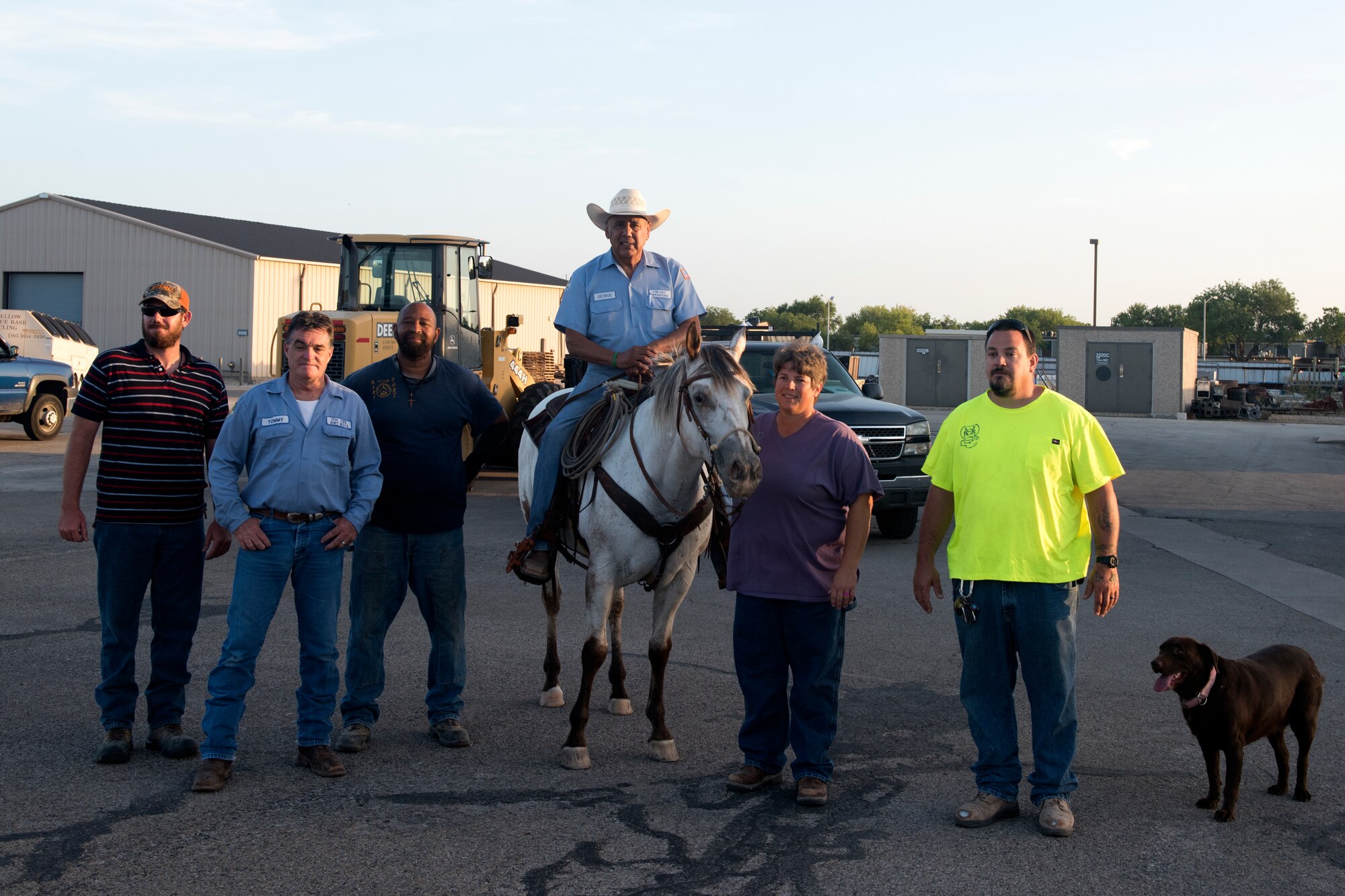 17th Civil Engineer Squadron heavy equipment operator, George Nava poses with other heavy equipment operators, called the dirt boys, at Goodfellow Air Force Base, Texas, June 29, 2018. Nava began his last day, before retirement, by checking off an item on his bucket list, riding to work on his horse. (U.S. Air Force photo by Airman 1st Class Zachary Chapman/Released)