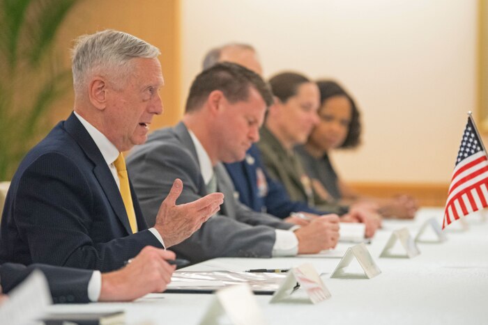 Defense Secretary James N. Mattis sits at a table with several people.