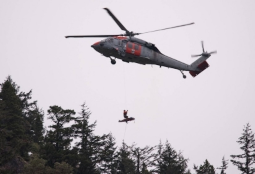 A hiker is hoisted aboard a helicopter.