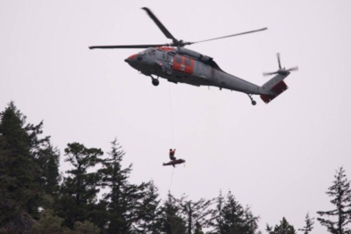 A hiker is hoisted aboard a helicopter.