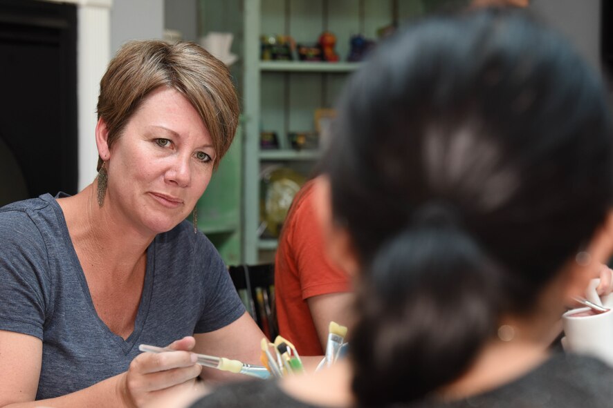 Paula Walker, the spouse of Chief Master Sgt. Justin Walker, 28th Mission Support Group superintendent, paints a piece of pottery and talks to another spouse during an event held by the 28th Bomb Wing Chapel in Rapid City, S.D., June 26, 2018. Multiple spouses came out to a pottery and painting activity hosted by the 28th Bomb Wing Chapel and went out to dinner afterward. (U.S. Air Force photo by Airman 1st Class Thomas Karol)