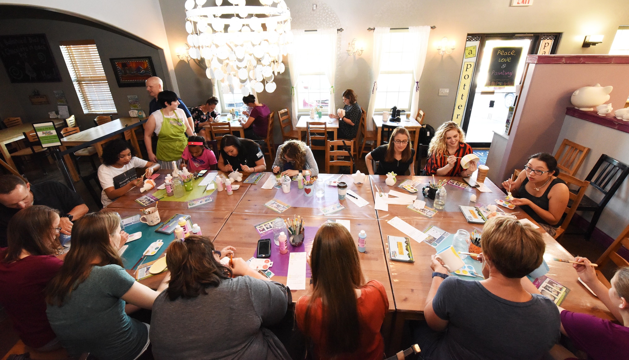 Spouses of deployed and remote Airmen and base members gather and paint various pieces of pottery in Rapid City, S.D., June 26, 2018. The 28th Bomb Wing Chapel hosted an event where spouses came out to paint pottery and form a network with other spouses. (U.S. Air Force photo by Airman 1st Class Thomas Karol)