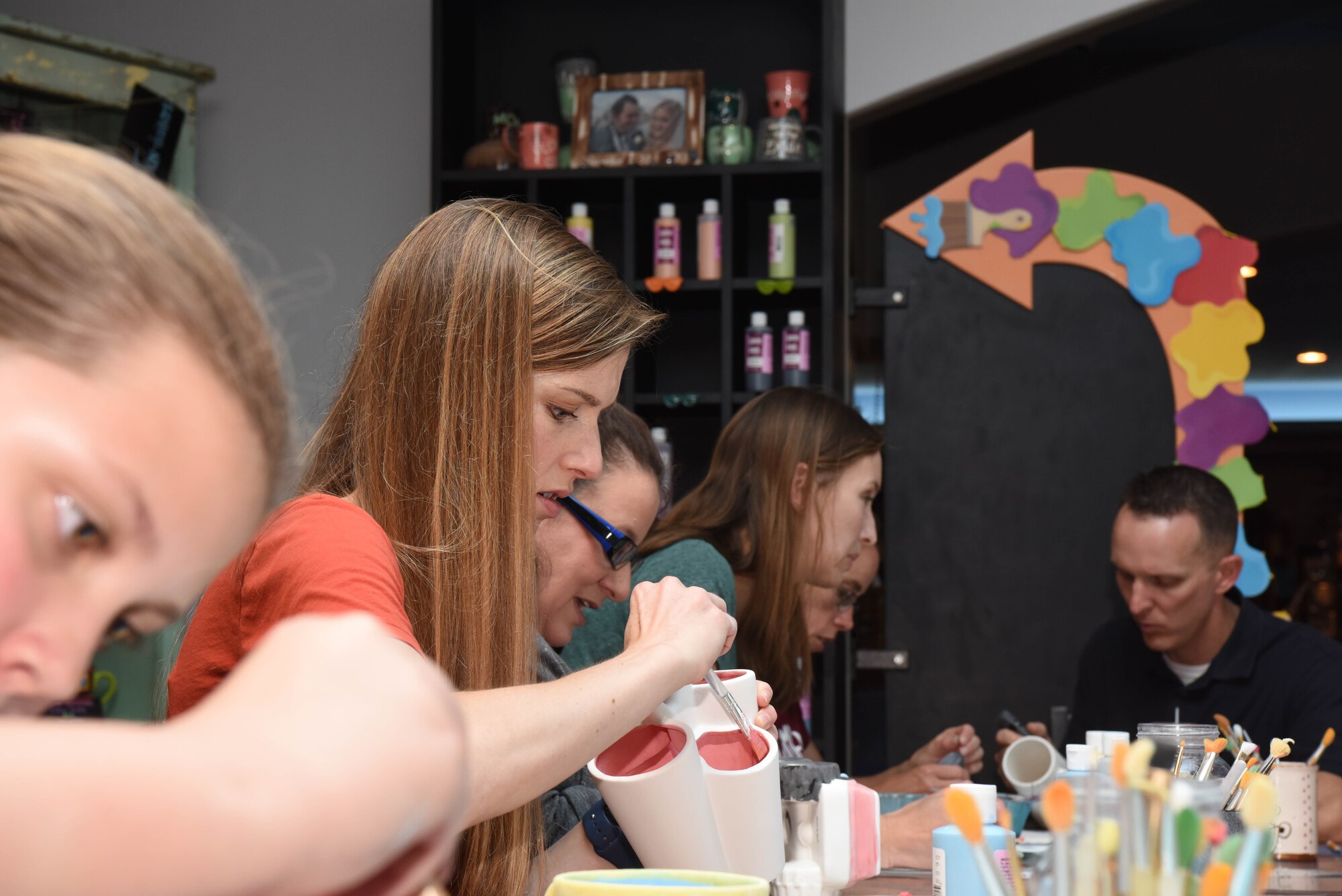 Spouses of deployed and remote Airmen paint pieces of pottery and talk to other base members in Rapid City, S.D., June 26, 2018. Spouses of deployed Airmen can sometimes become disconnected with the community, so the 28th Bomb Wing Chapel held an event where spouses came together to have fun and enjoy a dinner at a local restaurant. (U.S. Air Force photo by Airman 1st Class Thomas Karol)