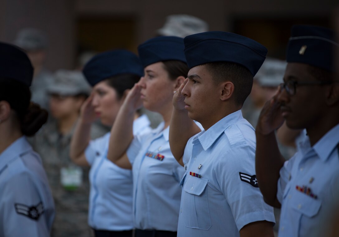 Airmen assigned to the 99th Medical Group render a salute during the playing of the National Anthem at Nellis Air Force Base, Nevada, June 29, 2018. The Airmen were part of the initial flight of Airmen during a change of command ceremony for the 99th MDG. (U.S. Air Force photo by Airman 1st Class Andrew D. Sarver)