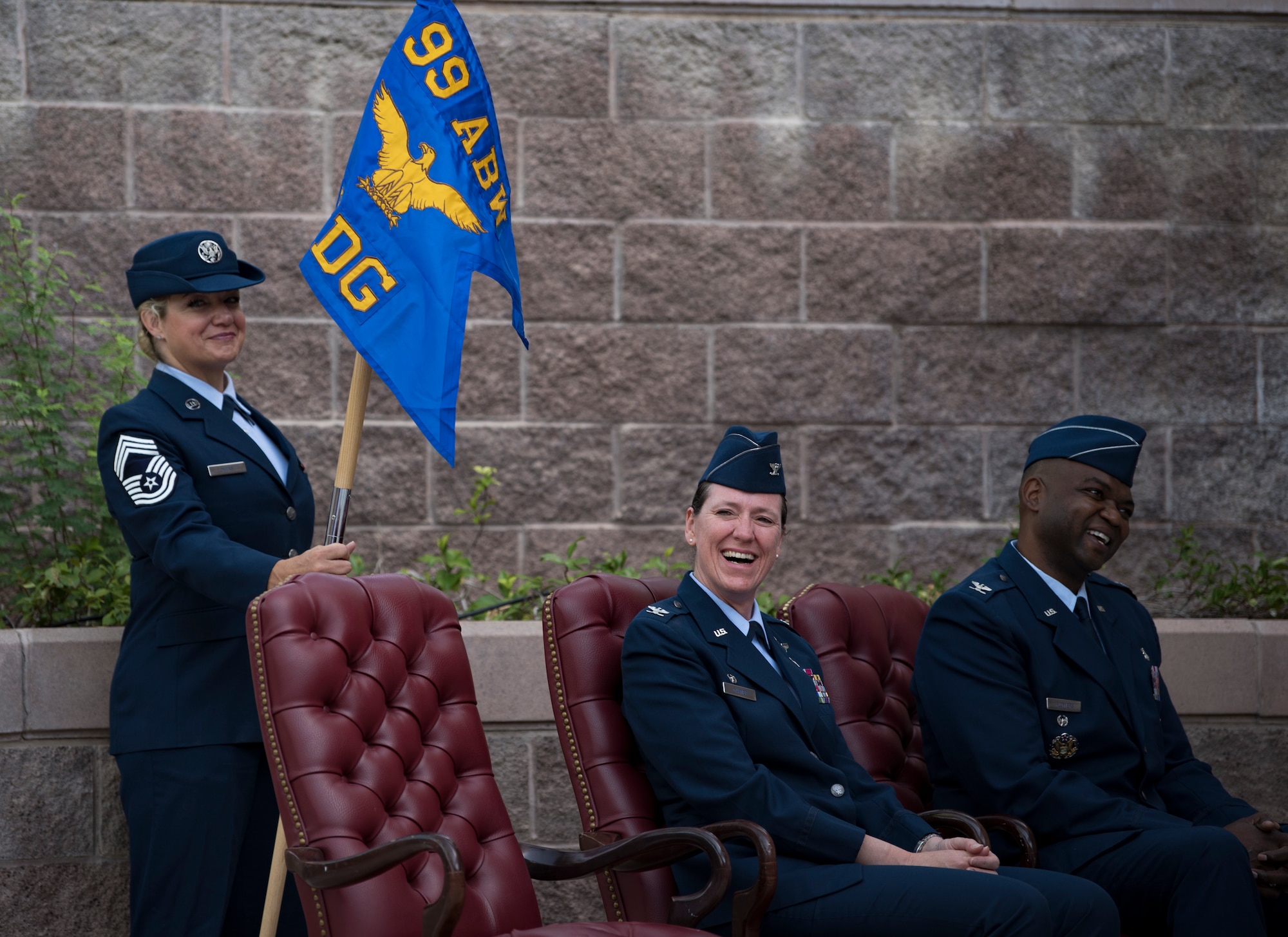 Chief Master Sgt. Nicole Owens, 99th Medical Group superintendent, Col. Virginia Garner, 99th MDG outgoing commander, and Col. Alfred Flowers Jr., 99th MDG incoming commander, laugh during a change of command ceremony at Nellis Air Force Base, Nevada, June 29, 2018. Change of command ceremonies are a military tradition and dates back to the time of Frederick the Great of Prussia. (U.S. Air Force photo by Airman 1st Class Andrew D. Sarver)