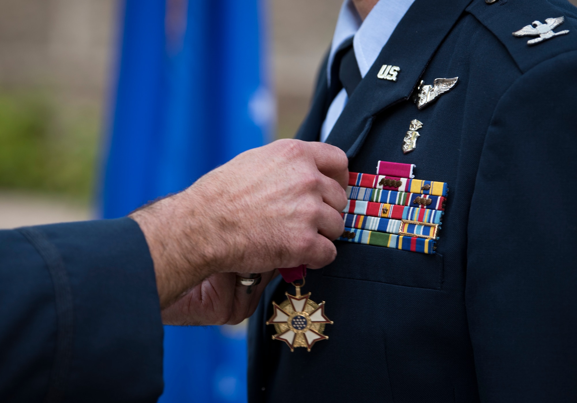 Col. Cavan Craddock, 99th Air Base Wing commander, awards a Legion of Merit to Col. Virginia Garner, 99th Medical Group commander during a change of command ceremony at Nellis Air Force Base, Nevada, June 29, 2018. The Legion of Merit is awarded for exceptional service. (U.S. Air Force photo by Airman 1st Class Andrew D. Sarver)