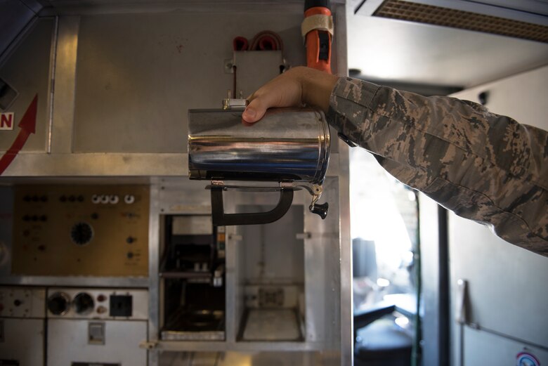 An Airman holds a hot cup inside a KC-10 Extender at Travis Air Force Base, Calif., June 21, 2018. The base is working on developing a new handle for the cup which could save the Air Force thousands. (U.S. Air Force photo by Tech. Sgt. James Hodgman)